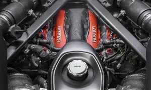 Silnik Ferrari v12, z czerwonymi pokrywami zaworów i charakterystycznym logo, gotowy do pracy.