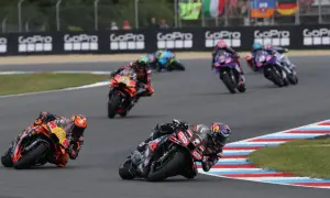 Motocykliści ścigają się na torze, tworząc dynamiczny obraz, który mógłby znaleźć się w każdym motogp kalendarz.