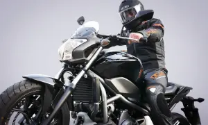 Motocyklista w kasku i kombinezonie siedzi na czarnym motocyklu. Zastanawiasz się, prawo jazdy a1 od ilu lat?