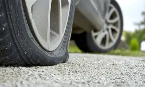 Opona runflat leży płasko na żwirze, sygnalizując awarię.