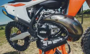 Potężny silnik dwusuwowy KTM z charakterystycznym wydechem FMF, gotowy do jazdy po bezdrożach.