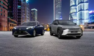 Dwa samochody, Toyota Mirai i bZ4X, na tle nocnego miasta. Zastanawiasz się, ile kosztuje samochód elektryczny?