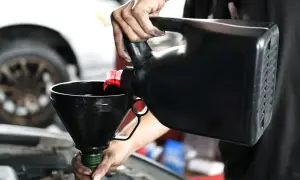 Mechanik wylewa olej do silnika. Czy lepszy będzie 5w30 czy 5w40?