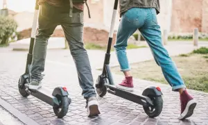 Dwie osoby na hulajnogach elektrycznych. Zastanawiasz się, od ilu lat można jeździć na hulajnodze elektrycznej?