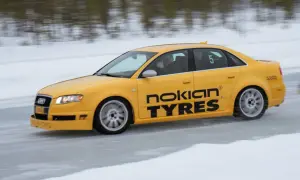 Żółty Audi S1 Quattro z napisem "Nokian Tyres" śmiga po lodowym torze. Kierowca pokazuje kciuk w górę.