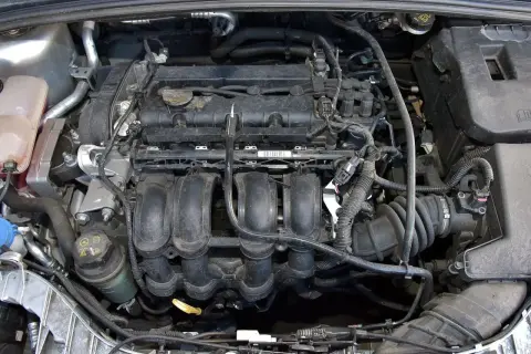 Silnik Ford Focus MK3 1.6 benzyna, widok z góry. Widać kolektor dolotowy, cewki zapłonowe i inne elementy.