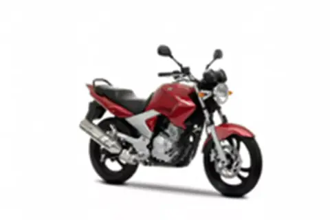 Czerwony motocykl Yamaha YBR 250 z czarnym siedzeniem i srebrnym wydechem, gotowy do jazdy po mieście.