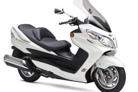 Biały Suzuki Burgman Executive, skuter z wygodnym siedzeniem i dużą szybą, gotowy na miejskie podróże.