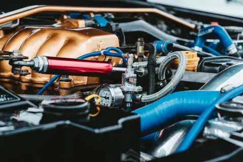 Zmodyfikowany silnik kei car z złotym kolektorem i czerwonym elementem.