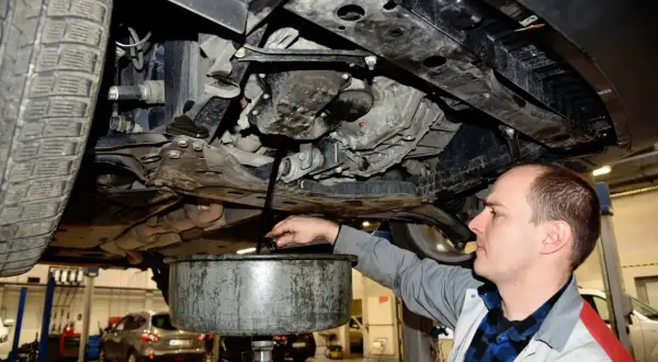 Mechanik spuszcza stary olej z silnika. Zastanawiasz się, ile trwa wymiana oleju? Zwykle to około 30-60 minut.