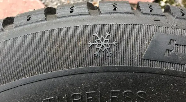 Płatek śniegu na bieżniku opony zimowej, symbolizujący gotowość na 3pmsf. Napis "TUBELESS" widoczny na bocznej ściance.