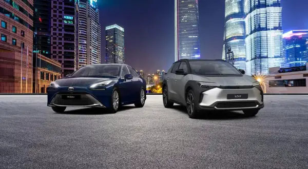 Dwa samochody, Toyota Mirai i bZ4X, na tle nocnego miasta. Zastanawiasz się, ile kosztuje samochód elektryczny?