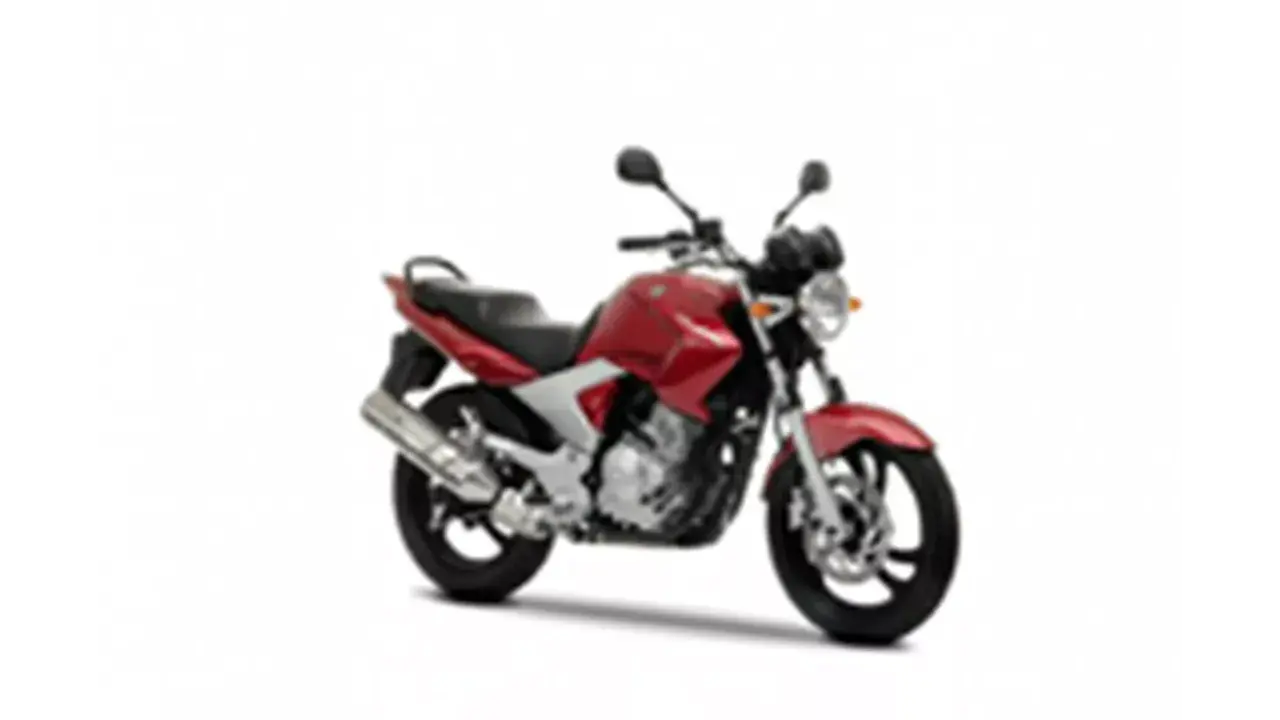 Czerwony motocykl Yamaha YBR 250 z czarnym siedzeniem i srebrnym wydechem, gotowy do jazdy po mieście.