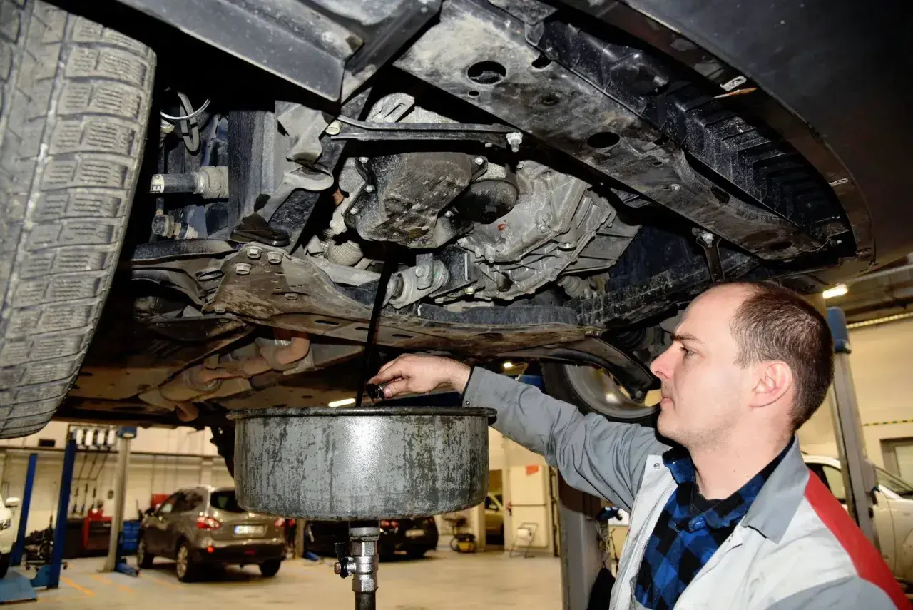 Mechanik spuszcza stary olej z silnika. Zastanawiasz się, ile trwa wymiana oleju? Zwykle to około 30-60 minut.