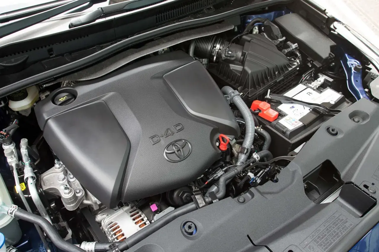 Silnik D-4D w Toyota Avensis T27, z widocznym logo Toyoty i elementami osprzętu, jak akumulator i obudowa filtra powietrza.