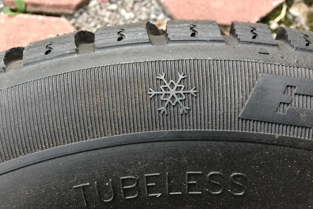 Płatek śniegu na bieżniku opony zimowej, symbolizujący gotowość na 3pmsf. Napis "TUBELESS" widoczny na bocznej ściance.