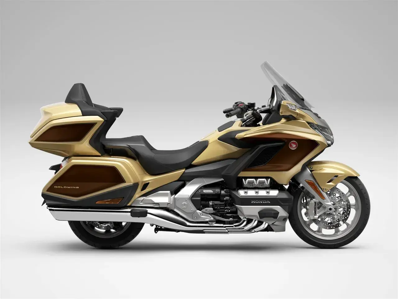 Złoty Honda Goldwing, luksusowy motocykl turystyczny z brązowymi akcentami, gotowy na dalekie podróże.