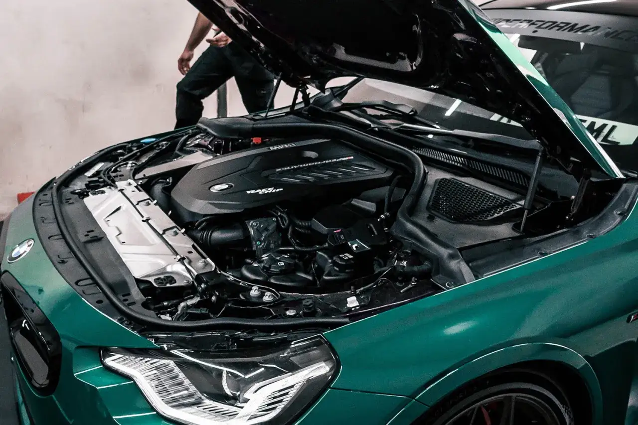 Zielony BMW z otwartą maską, ukazujący potężny silnik B58.