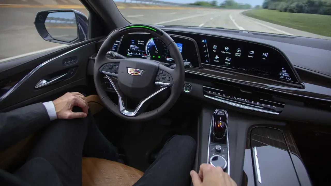 Wnętrze Cadillac Escalade 2025 z kierowcą, nowoczesnym panelem cyfrowym i ekranami.