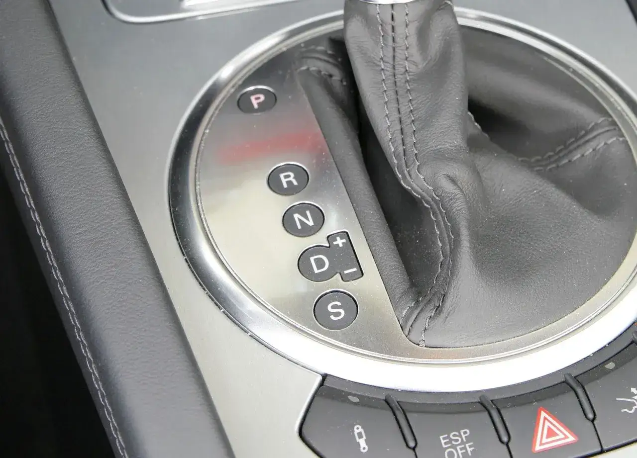 Zbliżenie na panel z oznaczeniami automatycznej skrzyni biegów: P, R, N, D (z możliwością ręcznej zmiany +/-) oraz S (Sport).