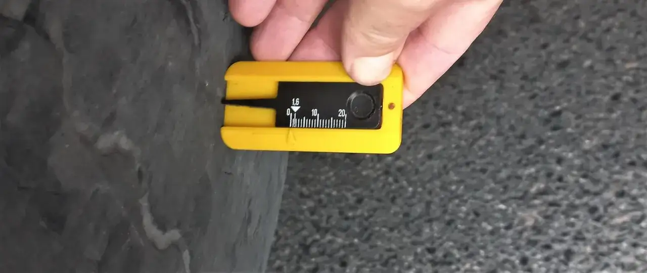 Żółty przyrząd do pomiaru bieżnika opony pokazuje 1,6 mm. To ważny pomiar, by sprawdzić stan opon.