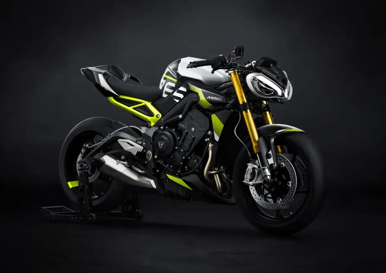Nowoczesny motocykl Triumph Speed Triple w jaskrawej kolorystyce z neonowymi akcentami, gotowy do podboju dróg.