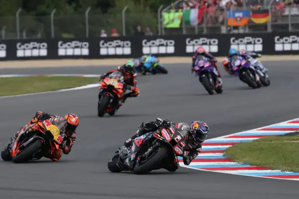 Motocykliści ścigają się na torze, tworząc dynamiczny obraz, który mógłby znaleźć się w każdym motogp kalendarz.