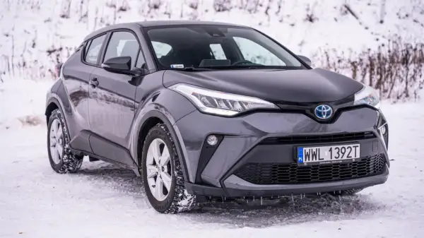 Szary Toyota C-HR 2025 na śniegu, gotowy na zimowe wyzwania.