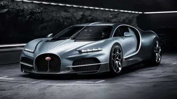 Srebrny Bugatti Tourbillon, symbol luksusu i mocy, prezentuje swoje aerodynamiczne linie w mrocznym wnętrzu.