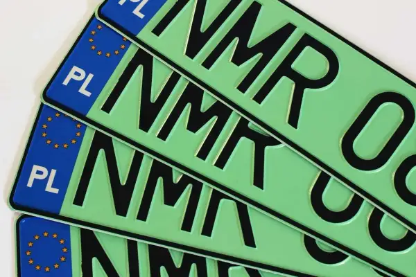 Kilka zielonych tablic rejestracyjnych z literami "NMR" i symbolem Unii Europejskiej.