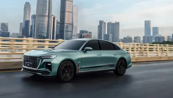Elegancki, zielony Hongqi H9 na tle drapaczy chmur. Sprawdź, jaka jest jego hongqi h9 cena i poczuj luksus.