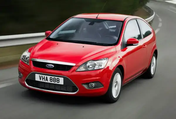 Czerwony Ford Focus MK2 1.6 TDCI w wersji 3-drzwiowej, jadący po zakręcie drogi.