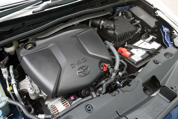 Silnik D-4D w Toyota Avensis T27, z widocznym logo Toyoty i elementami osprzętu, jak akumulator i obudowa filtra powietrza.