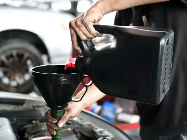 Mechanik wylewa olej do silnika. Czy lepszy będzie 5w30 czy 5w40?