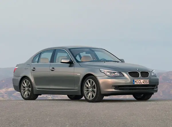 Szary sedan BMW 535d na tle górskiego krajobrazu.